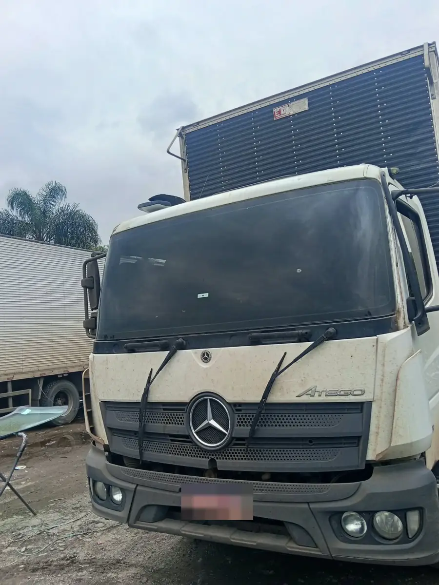 Caminhão Mercedes-Benz Atego branco com para-brisa novo instalado, placa oculta.